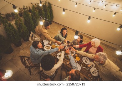 Storytelling footage of a multiethnic group of people dining on a rooftop. Family and friends make a reunion at home - Powered by Shutterstock