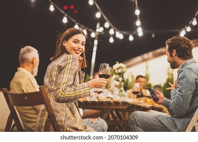 Storytelling image of a multiethnic group of people dining on a rooftop. Family and friends make a reunion at home.  - Powered by Shutterstock