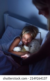Storytime in the digital age. Shot of a little girl and her mother using a digital tablet before bedtime.
