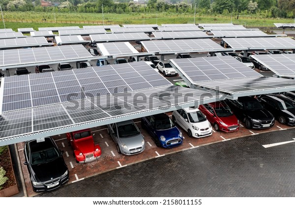 STOURTON, LEEDS, UK - MAY 16, 2022.\
 Aerial view above innovative solar panels located on a car parking\
lot rooftops making good use of small space in a\
city