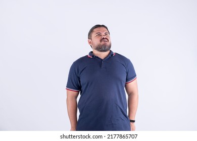 A Stout Man Tightens His Body Trying Not To Fat. Looking Funny And Feeling Embarrassed. Isolated On A White Background