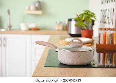 Stove with cookware in interior of modern kitchen