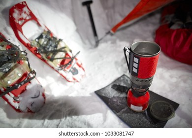 Stoves And Snowshoes Near The Tent In Winter Mountains Night.