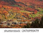 Stowe Mountain Resort in Stowe Vermont in fall Photo of the contrasting golf course green against the surrounding orange and yellow trees. Taken at the peak of the Fall foliage season in Stowe Vermont