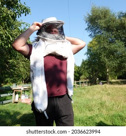 Stowmarket, Suffolk, UK - 5 September 2021: Bee Keeper Putting On Protective Clothing.