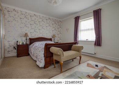 Stradishall, Suffolk, England - June 1 2017 Furnished Bedroom With Feature Wallpaper Wall And Sleigh Bed.