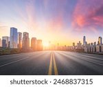 Straight asphalt highway road with modern city buildings at sunrise in Chongqing