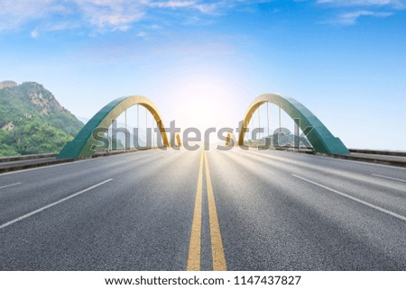 Straight asphalt road and beautiful mountain scenery under the blue sky