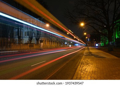 Straight Colorful Light Trails In The City At Night. Light Trails Goes High From The Road As Bus Is Passing By.