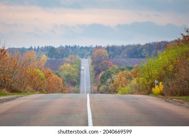 Straight Country Hillside Road In The Autumn Evening.