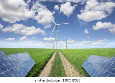 Straight Country Road To Wind Farm Through Solar Panels, Renewable Ecological Farm
