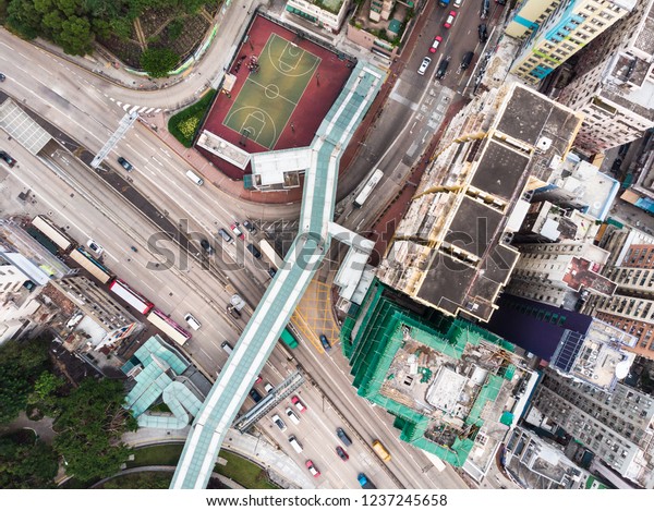 Straight\
down view of a foot bridge over a city street in a residential\
district of Kowloon city in Hong Kong,\
China