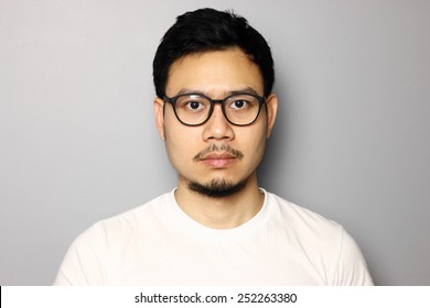 Straight Face Of Southeast Asian Man With Eyeglasses.