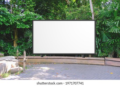 Straight Front Angle Of Large Empty Wooden Signboard For Advertising, Map Display Or Mockup Comping Purpose. Lush Green Background Behind Blank Display Billboard.