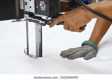Straight knife cutter and stainless steel gloves in a clothing factory