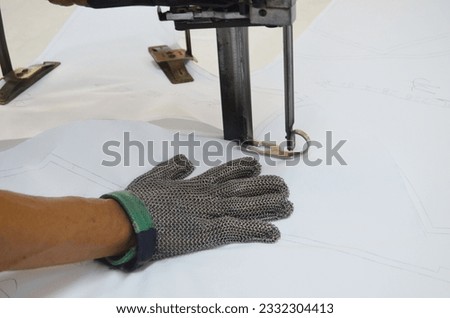 Straight knife cutter and stainless steel gloves in a clothing factory