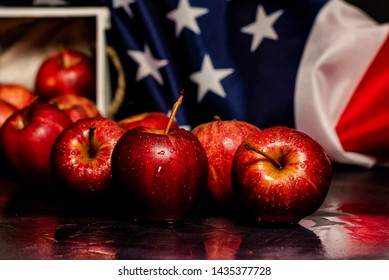 Straight On Picture Of Group Of Red Apples And Water On Them, American Flag Of Stars And Stripes At The Back