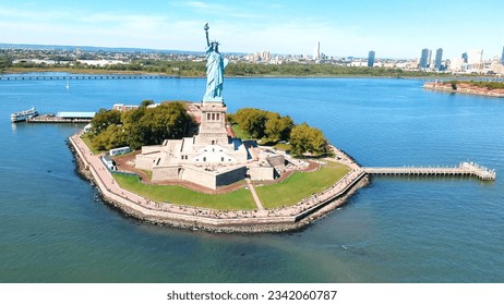 straight on shot of the Statue of Liberty with all of Star Island with tourists as seen from a helicopter flying over water