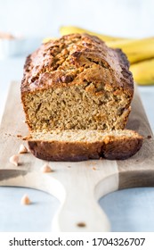 A Straight On Vertical View Of A Banana Bread Loaf That Is Sliced Into With One Slice In Front.