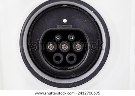 Straight on view of round receptacle for electric car power receptacle outline on white surface