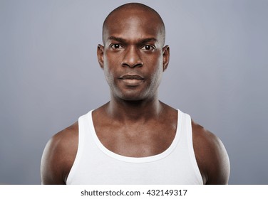 Straight on view of young single handsome African man with calm expression in white sleeveless undershirt - Powered by Shutterstock