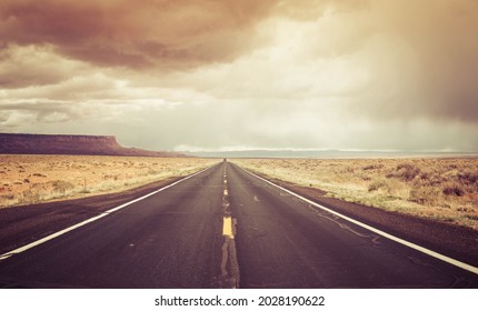 A Straight Road To The Distant Horizon Across The Desert Of Northern Arizona With The Vermillion Cliffs National Monument In The Distance On A Spring Day.