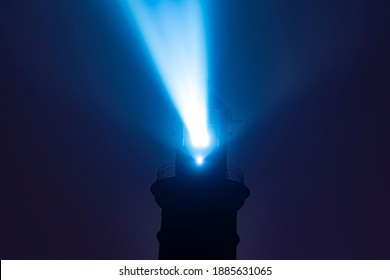 A straight view of a shining lighthouse tower beam on a foggy night - Powered by Shutterstock