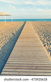 Straight Wooden Pathway On Empty Sand Beach In Spain By Evening
