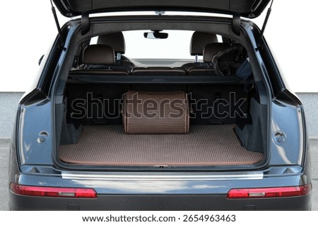 Straight-on view of an SUV’s open trunk lined with brown patterned mats and a structured storage bag. Rear seats are upright, showing the full layout of the clean and functional cargo space