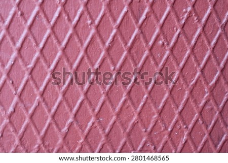 Straight-on view of a solid pink surface embossed with a distinct diamond-shaped crosshatch pattern grid.