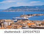 The Strait of Messina between Sicily and Italy. View from Messina town with golden statue of Madonna della Lettera and entrance to harbour. Calabria coastline in background