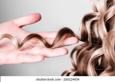 strand of curly blond hair on his arm - Shutterstock ID 260124434