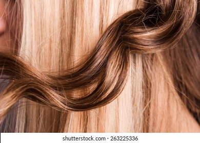 strand of curly blond hair on his arm - Shutterstock ID 263225336