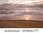 Strand in Nazaré in Portugal mit Wellen und Wolken