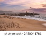 Strand in Nazaré in Portugal mit Wellen und Wolken