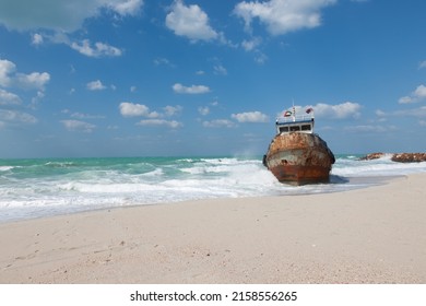 Stranded Rusty Fisherman Boat Photographed At The Coast Of Ajman Emirate On Sunny Winter Day  Sea, Sand, Blue Sky With Clouds At Background 