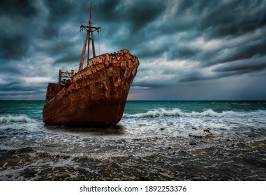 A stranded shipwreck at surf with rough sea and stormy sky
