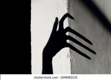 Strange Shadow On The Wall.Terrible Shadow. Abstract Background. Black Shadow Of A Big Hand On The Wall. Silhouette Of A Hand On The Wall. Nightmares. Scary Dreams.