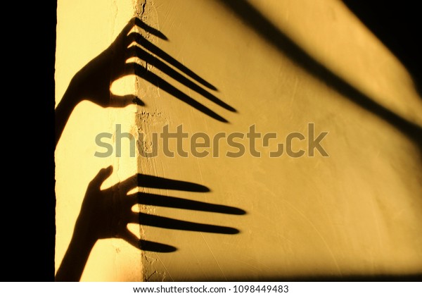 Strange Shadows On The
Wall.Terrible Shadows. Abstract Background. Black Shadows Of A Big
Hands On The Wall. Silhouette Of A Hands On The Wall. Nightmares.
Scary Dreams.