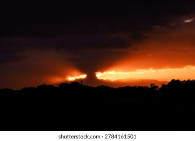 strange shape of clouds that let the light of the sunset appear 