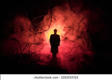strange silhouette in a dark spooky forest at night, mystical landscape surreal lights with creepy man