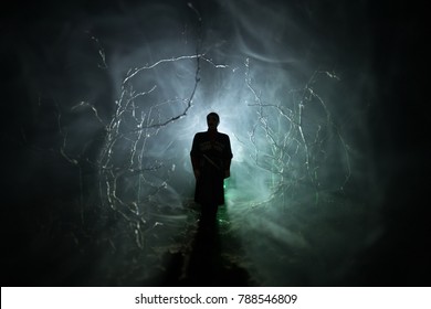 Strange Silhouette In A Dark Spooky Forest At Night, Mystical Landscape Surreal Lights With Creepy Man