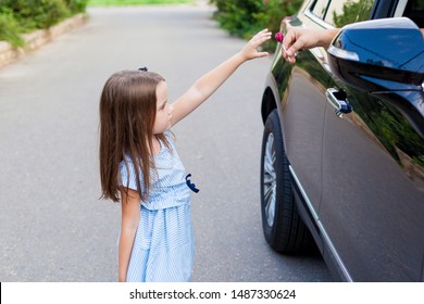 Stranger In The Car Offers Candy To The Child. Kids In Danger. Children Safety Protection Kidnapping Concept. 