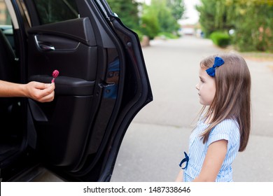 Stranger In The Car Offers Candy To The Child. Kids In Danger. Children Safety Protection Kidnapping Concept.