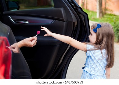 Stranger In The Car Offers Candy To The Child. Kids In Danger. Children Safety Protection Kidnapping Concept.