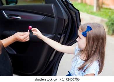 Stranger In The Car Offers Candy To The Child. Kids In Danger. Children Safety Protection Kidnapping Concept