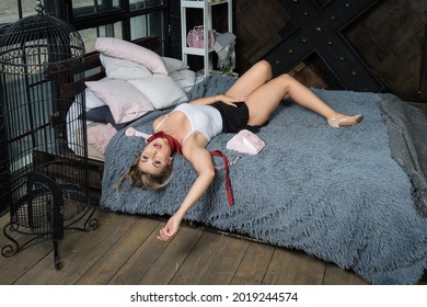 Strangled beautiful woman in a bedroom. Simulation of the crime scene.