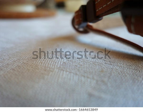 strap from\
the leather camera case on the\
tablecloth
