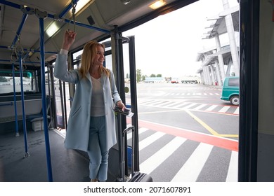 Straphanger With Boarding Ticket And Baggage Riding Airport Shuttle Bus