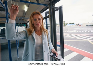 Straphanger With Travel Document Riding Airport Shuttle Bus